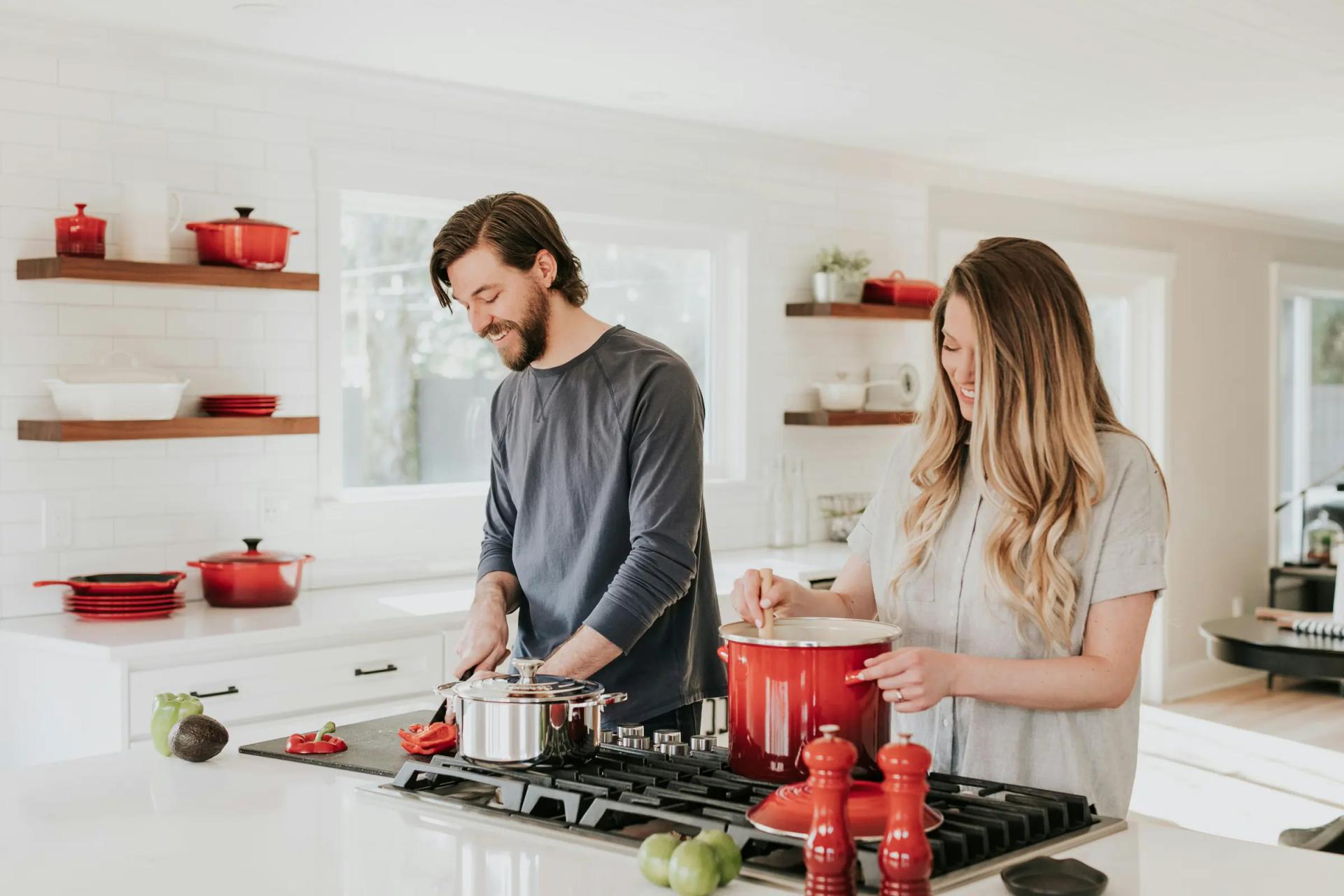 A couple cooking together in a clean kitchen